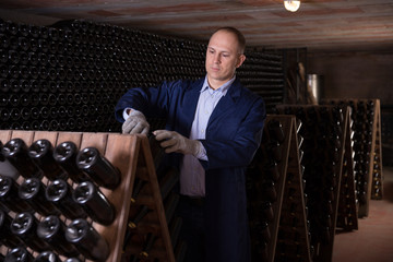 Winemaker checking bottles with wine