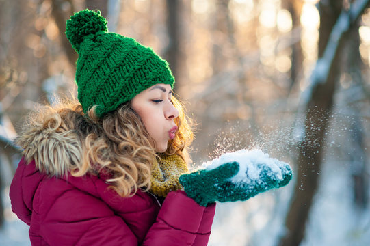 Attractive young girl in wintertime outdoor blowing snow