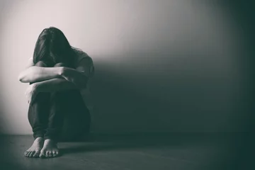 Teenager-Mädchen mit Depressionen, die allein auf dem Boden im dunklen Raum sitzen. . Schwarz-Weiß-Foto © Stanislaw Mikulski