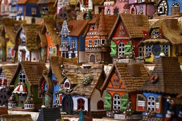 Obraz premium Florence, November 2018: Christmas Ornaments in a Christmas Market. colored little houses in a market. Xmas time in Italy.