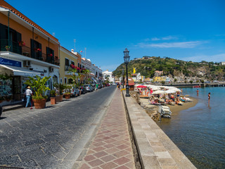 Fototapeta na wymiar Lacco Ameno, Corso Angelo Rizzoli, beach with colorful houses and restaurant, island of Ischia, Naples, Gulf of Naples, Campania, Italy
