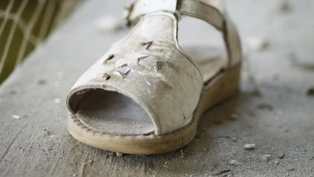 Children's sandal left in a ruined house of kindergarten in the abandoned city of Pripyat after the tragedy at the nuclear power plant in Chernobyl. Conceptual video about child missing or kidnapping