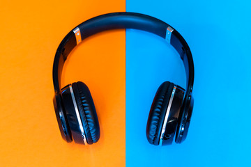 Black Wireless Headphones on a split  orange and blue background
