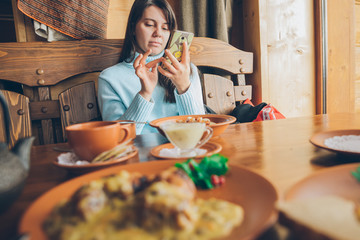 woman sitting in cafe and chatting on phone