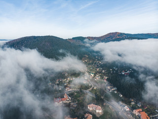 aerial view of village in mountains clouds over it