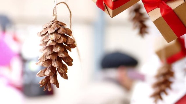 Hanging pine cone and presents with red ribbon in traditional Christmas market