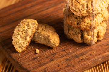 Homemade oatmeal cookies on wooden board on old table background