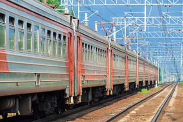 Obraz na płótnie Canvas Close up view of a passing electric train moving against a blue sky
