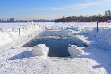Obraz premium Ice-hole in the lake illuminated by sunlight