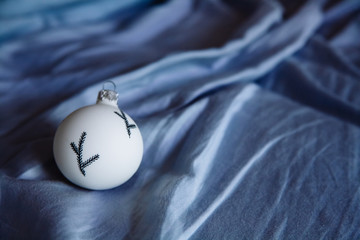 Christmas glass toy on blue sheets. Close up