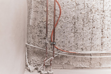 Pipe and cable on non-plastered wall