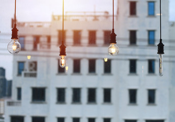 Obraz premium Edison lamp, vintage style bulb, background image is evening sky and building