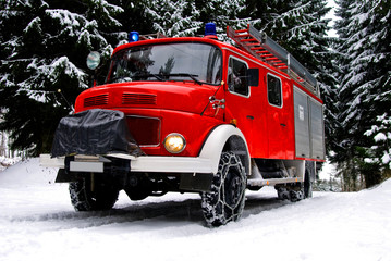 Löschfahrzeug der Feuerwehr mit Schneeketten im Schnee