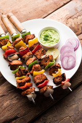 Indian chicken tikka kebabs, marinated in spices and yogurt and roasted in tandoor. served with green chutney and onion. selective focus