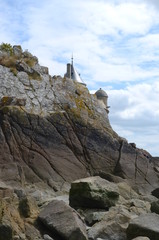 Fototapeta premium Rocks and top of a tower at Mont Saint Michel