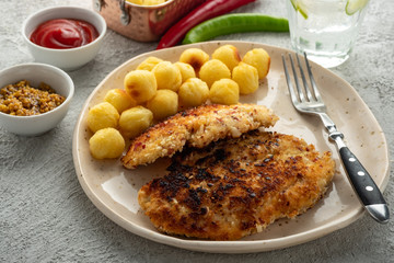 Wiener schnitzel with potato balls and lemon sauce. Chicken schnitzel in breading