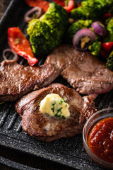 Grilled Beef steak with garlic butter and vegetables. Meat with grilled bell pepper, broccoli and onions.