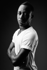 Naklejka premium Young African man against black background in black and white