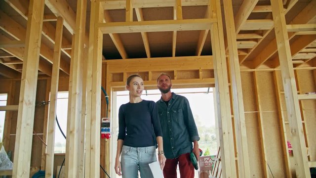 Two young people discussing the construction of a house inside the house. Medium shot. Soft focus