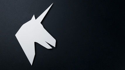 Head of a unicorn of paper on a black background. Artwork. Copy space. Top view. Flat lay. Fantasy сoncept