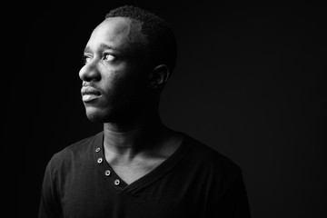 Young African man against black background in black and white