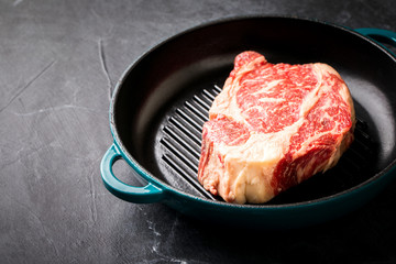Raw Fresh Marbled Meat Beef Steak on the grill pan. Copy space for Text