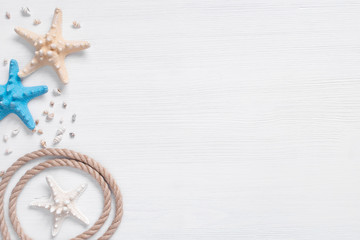 White wooden background with starfishes and rope