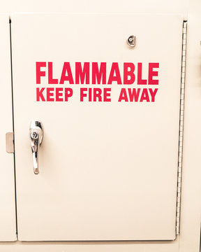 A chemical cabinet in a research laboratory that is designed to keep flammable material away from outside contact. "FLAMMABLE Keep Fire Away" is clearly visible in a vibrant red color.
