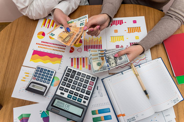 Female hands with dollar and euro exchanging with each other