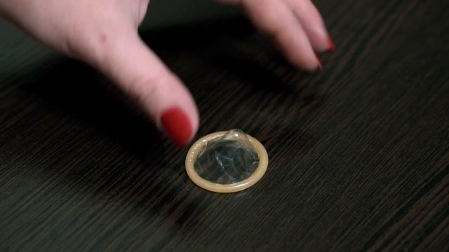 Condom put on a table. Wood background