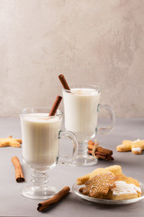 Christmas eggnog in glass mug and cinnamon.