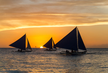Fototapeta na wymiar Small sailing boats at the sunset. Boracay, Philippines