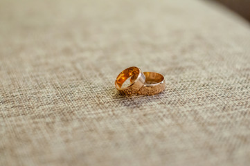 Pair of gold wedding rings on the grey background