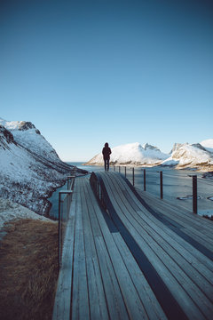 Person looking at snow covered mountains and river