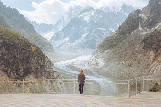 Rear view of woman standing on bridge against mountains