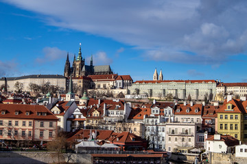Naklejka na ściany i meble Prague, Czech Republic, Europe, panorama overlooking the historic buildings of Prague Castle, Charles Bridge and the Vltava River in front of interesting blue sky with clouds