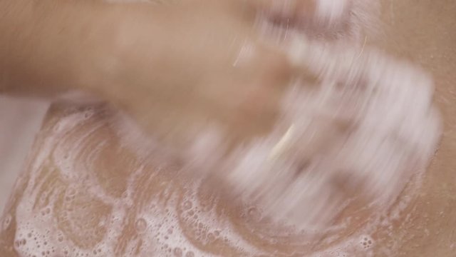 A woman's hand rubs her belly. In the image you see only the hand, the foam and the belly