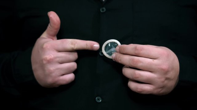 Safe sex concept. Condom in man hand