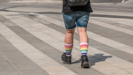 Fototapeta na wymiar Men legs in colorful rainbow socks on street background, shot in Stockholm, Sweden, horizontal, copy space