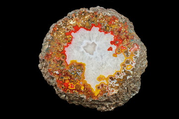 A cross-section of agate. In the outer part multicolored silica bands colored with metal oxides are...