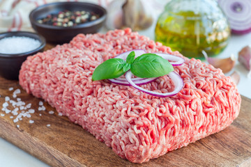 Minced meat from pork and beef. Ground meat with ingredients for cooking on wooden board, horizontal