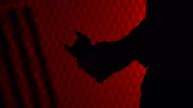 MAN IN SILHOUETTE PULLS A STUN GUN AND TRIGGERS IT.  IN 4K, 10 BIT, 4:2:2.