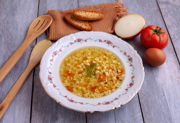 Gardening soup in porcelain plate, tomato, onion, egg and wooden  spoons