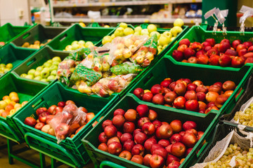 Bunch of red and green apples on boxes in supermarket