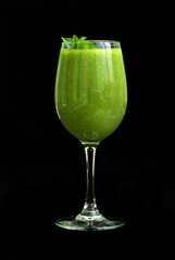 Green smoothies (drink) in a glass on a black background. Isolated object