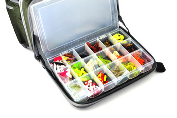 A box with a variety of silicone baits lies in a fishing bag, white background close-up © Александр Юркевич