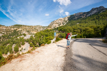 Fototapeta premium Emotional hitchhiker try to stop a passing car