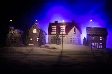 Little decorative houses, beautiful festive still life, cute small houses at night, Night city real bokeh background, happy winter holidays. Selective focus