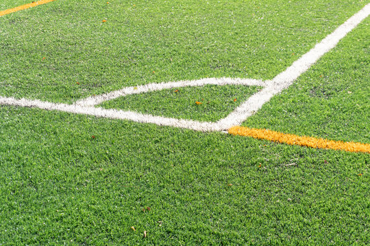 Soccer field with a new artificial turf field, white corner marking. Close up. Soccer background. Copy space