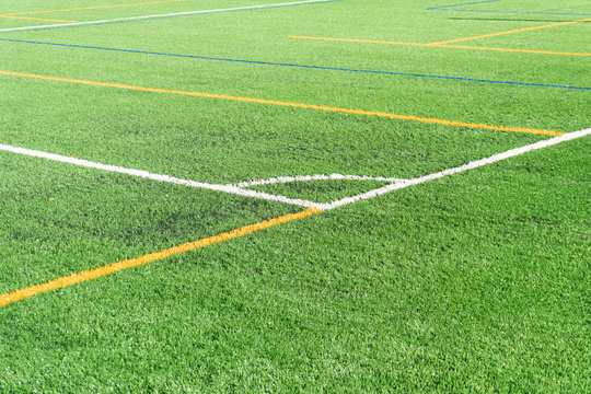 Soccer field with a new artificial turf field, white corner marking. Close up. Soccer background. Copy space